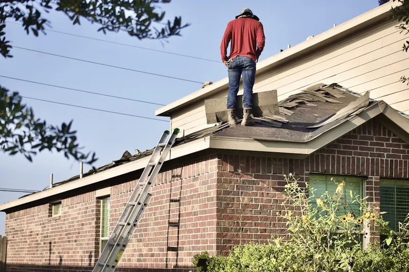 Professional roofer working on a residential roof in Otsego